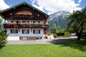 a house with a balcony with flowers on it at Gästehaus Sonnenheim in Mittenwald