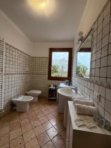 a bathroom with a tub and a toilet and a sink at ZIO CESARE FOSSO' 4 int 2 in Fossò