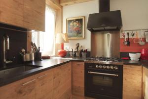 a kitchen with a stove and a sink in it at Brand new beautiful ground floor flat in Cortina dʼAmpezzo
