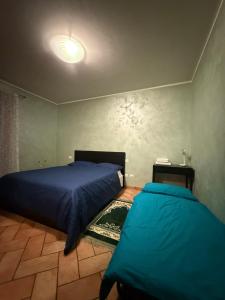 a bedroom with two beds with blue sheets at ZIO CESARE FOSSO' 4 int 2 in Fossò