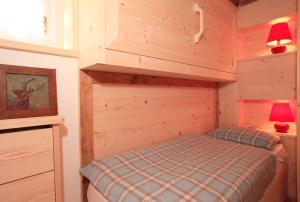 a small bedroom with a bed in a cabin at Brand new beautiful ground floor flat in Cortina dʼAmpezzo