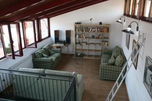 a living room with two couches and a book shelf at Hotel Rural Las Grullas in Villanueva del Fresno