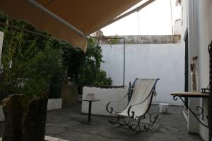 a chair sitting on a patio with a table at Hotel Rural Las Grullas in Villanueva del Fresno