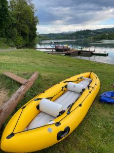 a yellow kayak sitting on the grass next to a lake at Osada Pienińska in Krościenko +85 photos
