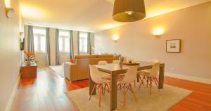 a dining room and living room with a table and chairs at ALIADOS by YoursPorto in Porto