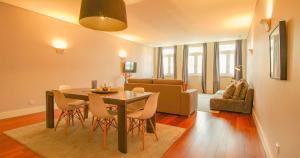 a dining room and living room with a table and chairs at ALIADOS by YoursPorto in Porto