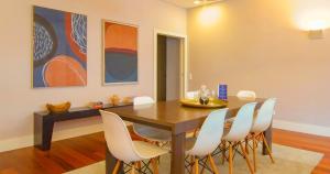 a dining room with a wooden table and white chairs at ALIADOS by YoursPorto in Porto