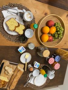 a table topped with baskets of bread and fruit at Le Clos 1003 in Saint-Didier-sur-Chalaronne