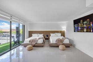 a bedroom with two beds and a large window at Waterfront Luxe Condo - Close to beach in Hallandale Beach