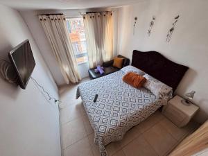 a small bedroom with a bed and a window at ApartaHotel Holguin in Estación El Salto