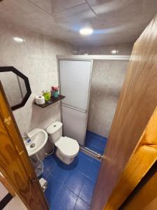a bathroom with a toilet and a sink at ApartaHotel Holguin in Estación El Salto