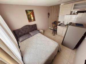 a small bedroom with a bed and a kitchen at ApartaHotel Holguin in Estación El Salto +2 photos