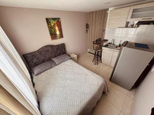 a small bedroom with a bed and a refrigerator at ApartaHotel Holguin in Estación El Salto