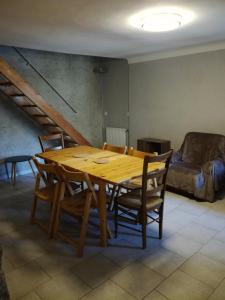 a wooden table and chairs in a room with a couch at Maison à Briançon in Briançon