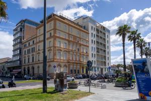 a large building on a city street with palm trees at Charming beach front apartment in Viareggio