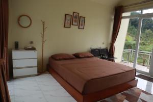 a bedroom with a large bed and a window at Diiza Glamping Tawangmangu Private Pool No BBQ in Tawangmangu