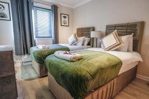 a bedroom with two beds with towels on them at Burnvale Apartment in Livingston