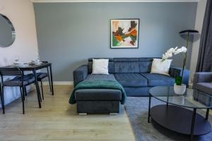 a living room with a blue couch and a table at Burnvale Apartment in Livingston