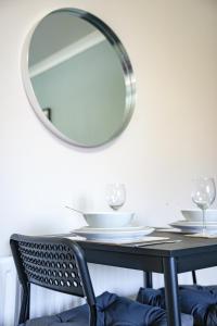 a table with a mirror and a black chair at Burnvale Apartment in Livingston