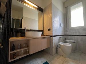 a bathroom with a sink and a toilet at Charming beach front apartment in Viareggio +14 photos