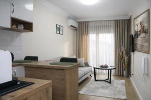 a kitchen and living room with a couch and a table at Apartman Jaman - Novi Pazar in Novi Pazar