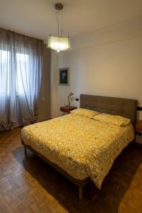 a bedroom with a bed with a yellow comforter at Charming beach front apartment in Viareggio