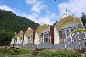 a row of houses with mountains in the background at Diiza Glamping Tawangmangu Private Pool No BBQ in Tawangmangu