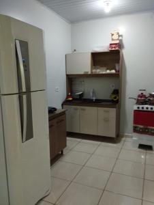 a kitchen with a refrigerator and a stove at Recanto da LM in Foz do Iguaçu +3 photos