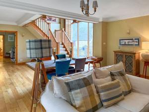 a living room with a couch and a staircase at Church Barn in Olney