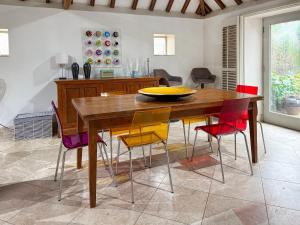 a dining room with a wooden table and colorful chairs at Church Barn in Olney