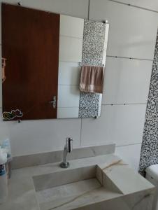 a bathroom with a sink and a mirror at Recanto da LM in Foz do Iguaçu
