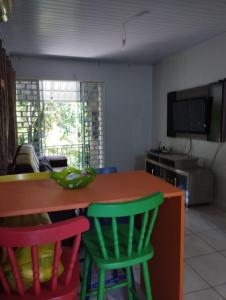 a kitchen with colorful chairs at a table at Recanto da LM in Foz do Iguaçu