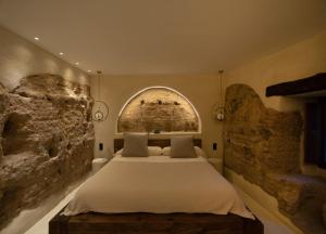 a bedroom with a large bed in a stone wall at Espacio Biocompatible - Villa Raíz in Requena