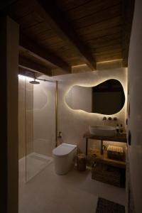 a bathroom with a toilet and a sink and a mirror at Espacio Biocompatible - Villa Raíz in Requena