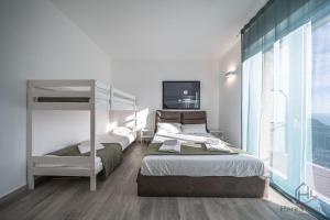 a bedroom with two beds and a bunk bed at Panorama Blu - Spiaggia 7min - Terrazza - WiFi in Celle Ligure