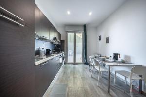a kitchen with a table and some chairs in it at Panorama Blu - Spiaggia 7min - Terrazza - WiFi in Celle Ligure +20 photos