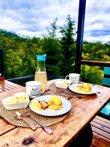 a wooden table with plates of breakfast food on it at Kamarí Glamping in San Francisco