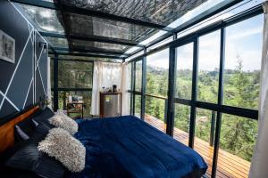 a bedroom with a bed in a room with windows at Kamarí Glamping in San Francisco