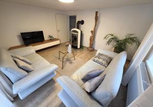a living room with two white couches and a tv at Bodensee Ferienwohnung Claudia 4 in Friedrichshafen