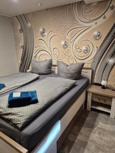 a bedroom with two beds and a wall with flowers at Ferienwohnung Puchfrie in Bad Sooden-Allendorf