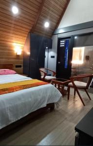 a bedroom with a large bed and two chairs at Winter Whisper in Jāmb +5 photos
