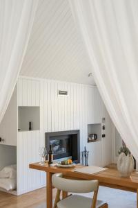 a dining room with white walls and a table and chairs at Casa do Rio - Douro Wine Hotel by Vallado in Vila Nova de Foz Coa