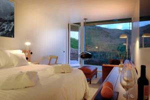 a bedroom with a bed and a large window at Casa do Rio - Douro Wine Hotel by Vallado in Vila Nova de Foz Coa +42 photos