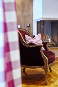 two chairs with pillows in front of a fireplace at Suite Buche - Chalet Bergerhöh in Bad Wiessee