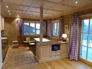a kitchen with a large island in a room with windows at Suite Buche - Chalet Bergerhöh in Bad Wiessee