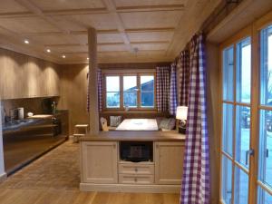 a kitchen with a sink and a large window at Suite Buche - Chalet Bergerhöh in Bad Wiessee