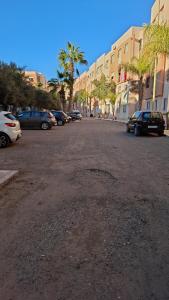a parking lot with cars parked in front of buildings at Le cocon drargua in Agadir