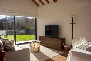 a living room with a flat screen tv and a couch at Quinta das Candeias - Casa da Bé in Arcos de Valdevez