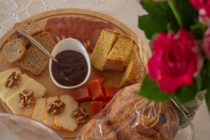 a plate of food with meat cheese bread and fruit at Quinta das Candeias - Casa da Bé in Arcos de Valdevez +2 photos