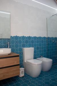 a bathroom with a toilet and a sink and a tub at Quinta das Candeias - Casa da Bé in Arcos de Valdevez